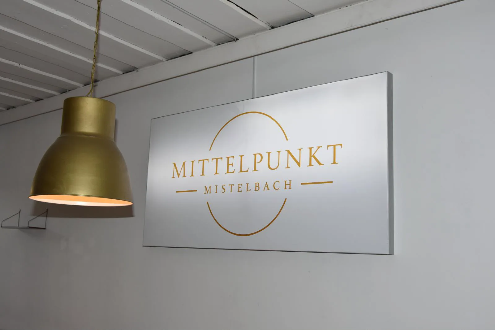 Beleuchtetes Logo des Mittelpunkt Mistelbach im Gastraum